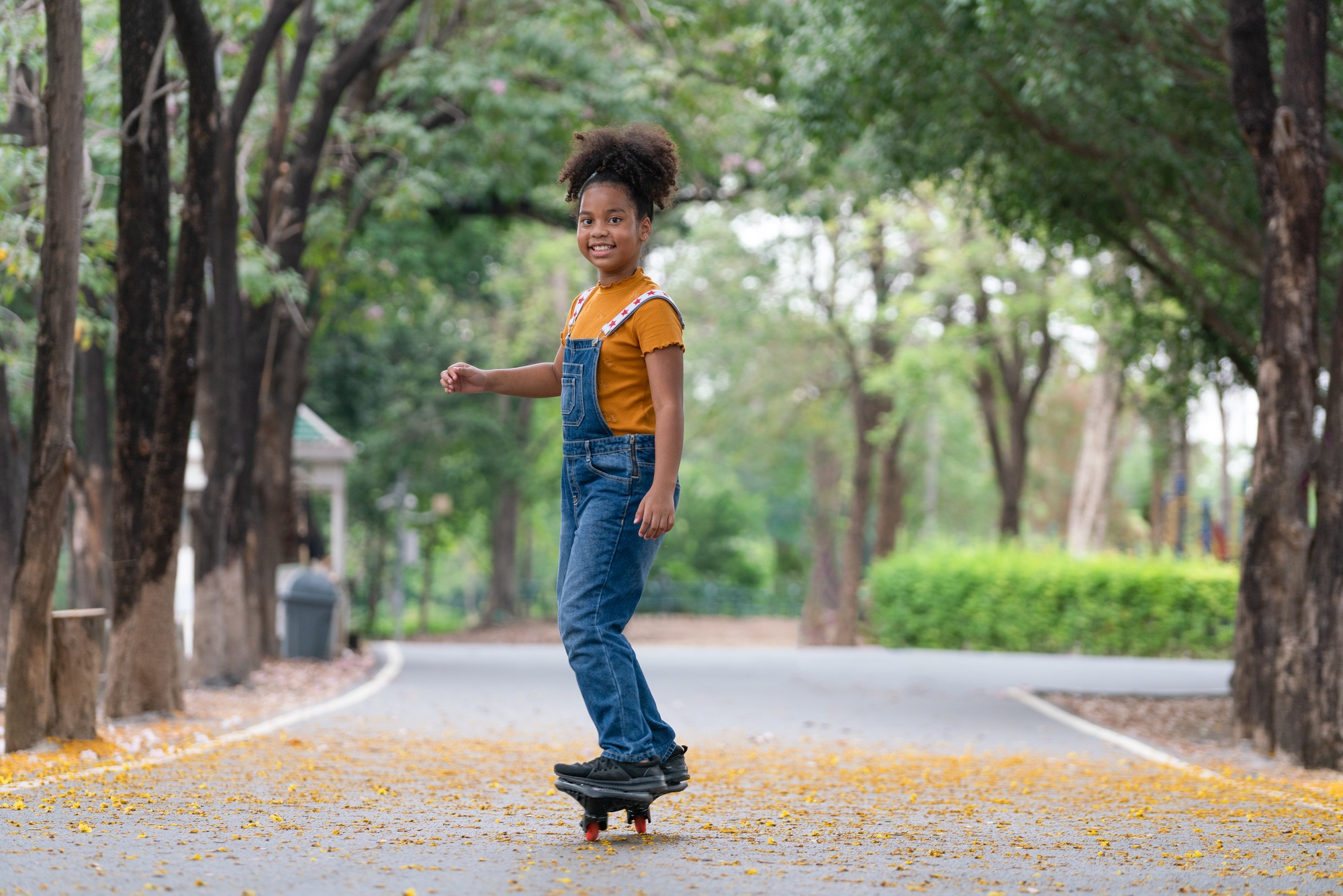 Happy African American girl playing skateboard in park, Sport outdoor for kid.