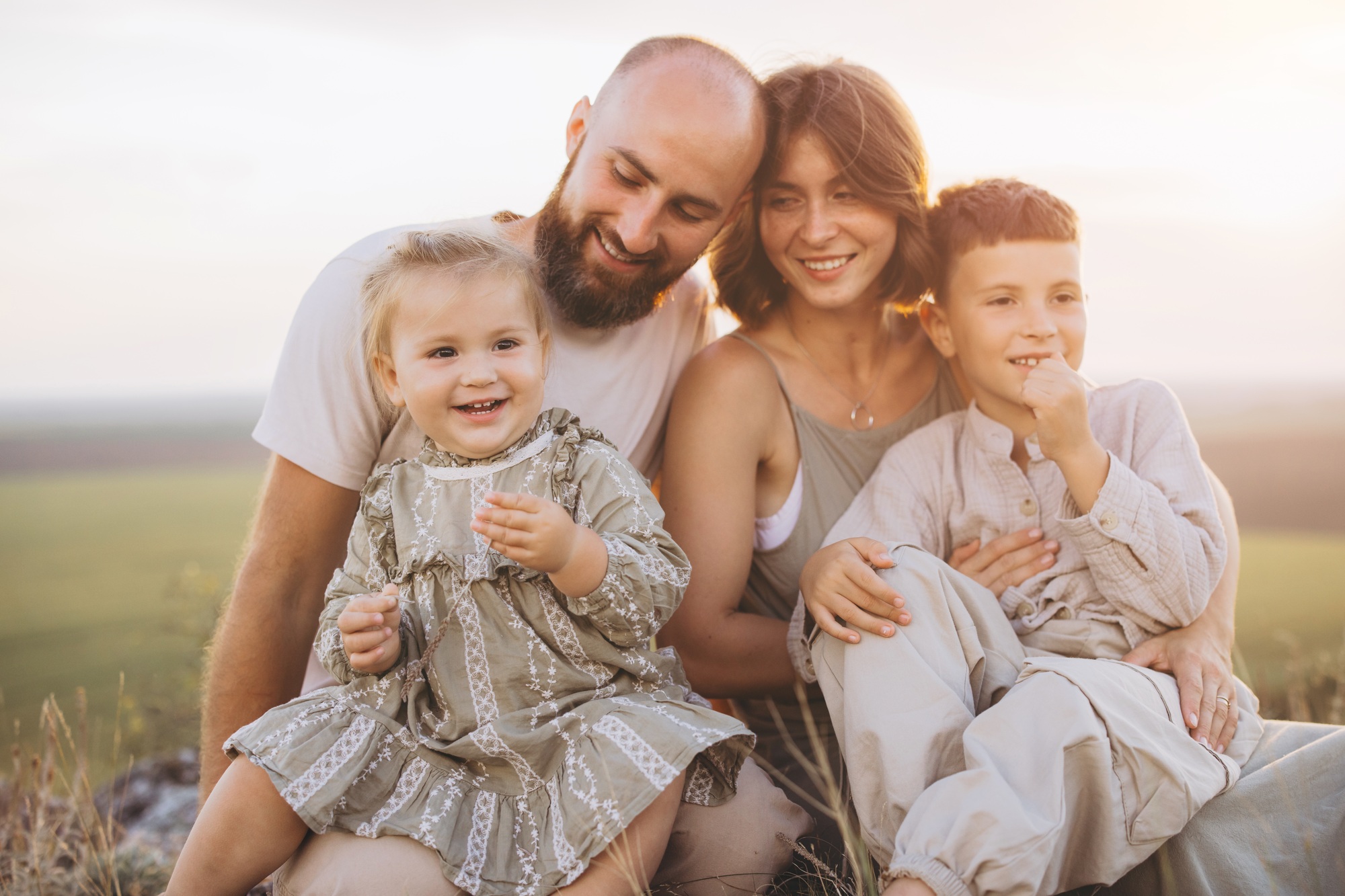 Happy Family Enjoying Outdoors Together in Warm Sunlight at Sunset