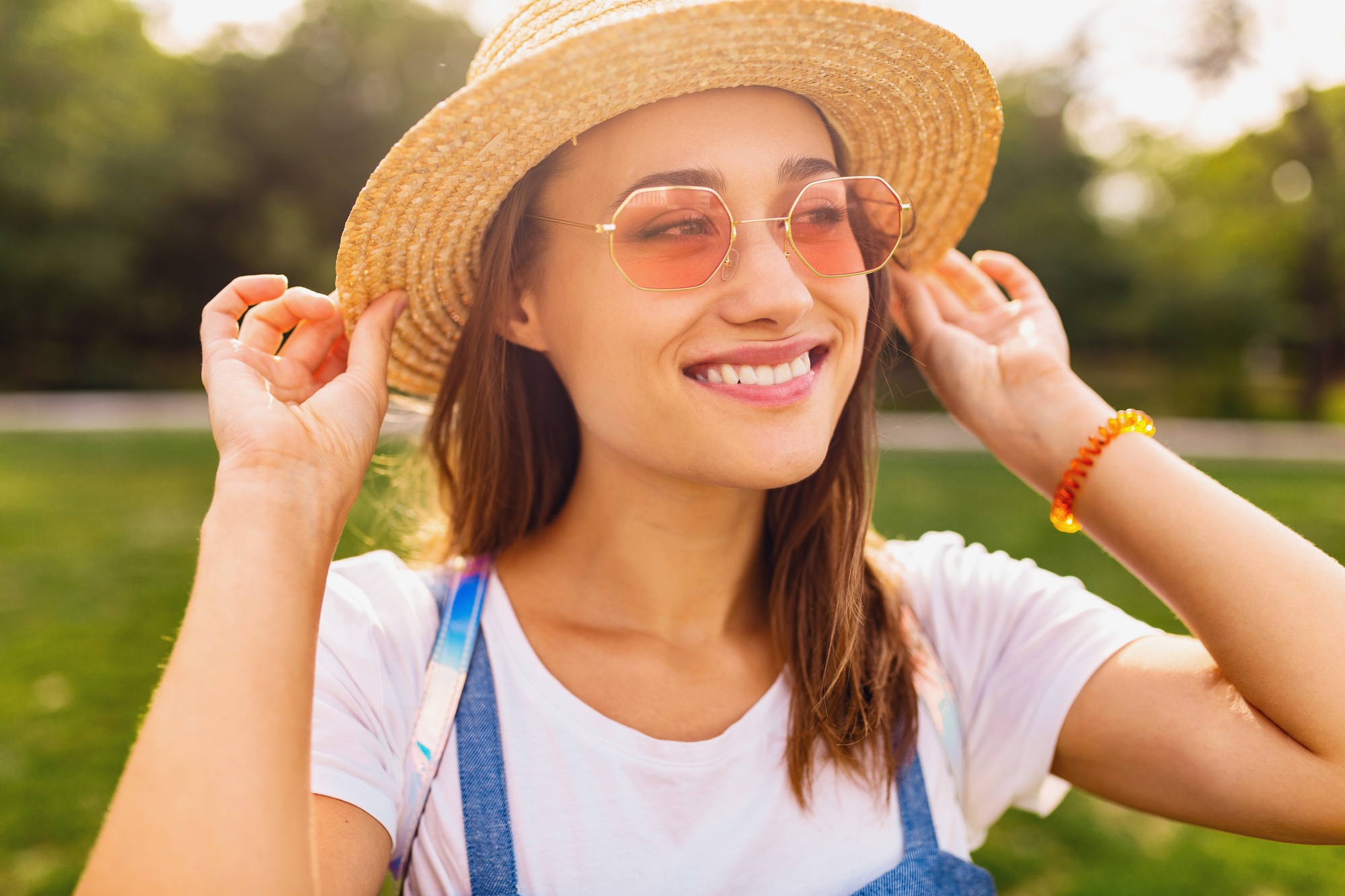 portrait of young pretty smiling woman in straw hat